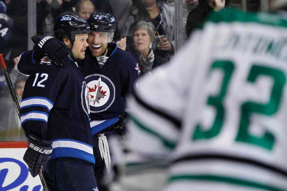 JOHN WOODS / THE CANADIAN PRESS
Olli Jokinen (left) and Blake Wheeler (centre) celebrate Wheeler's goal against Dallas Stars goaltender Kari Lehtonen during the second period.