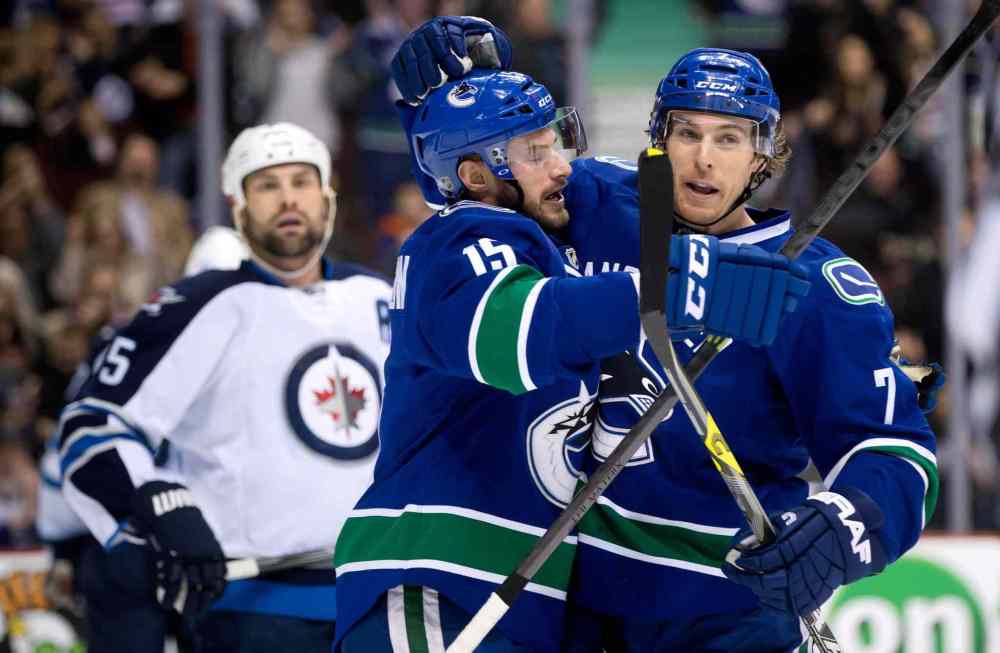 DARRYL DYCK / THE CANADIAN PRESS
Brad Richardson (centre) and David Booth (right) of the Vancouver Canucks celebrate Richardson's goal as Winnipeg Jets defenceman Mark Stuart looks on.
