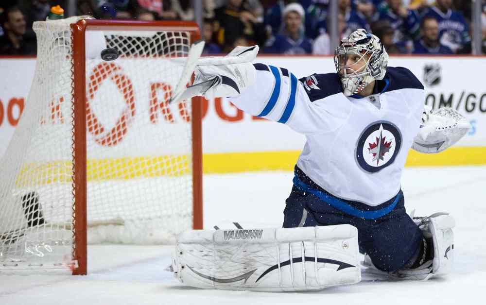 DARRYL DYCK / THE CANADIAN PRESS
Winnipeg Jets goalie Ondrej Pavelec uses his stick to deflect a shot by Vancouver Canucks forward Ryan Kesler wide of the goal during the first period.