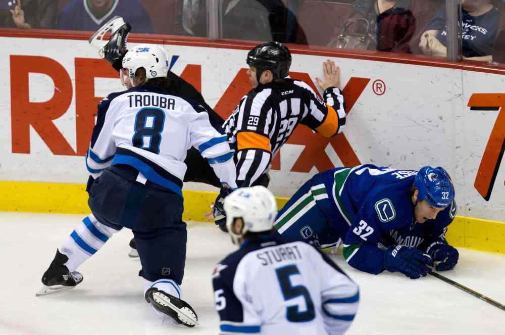 DARRYL DYCK / THE CANADIAN PRESS
Referee Ian Walsh (centre) is knocked to the ice after Winnipeg Jets defenceman Jacob Trouba (left) and Vancouver Canucks' Dale Weise collided during the second period.