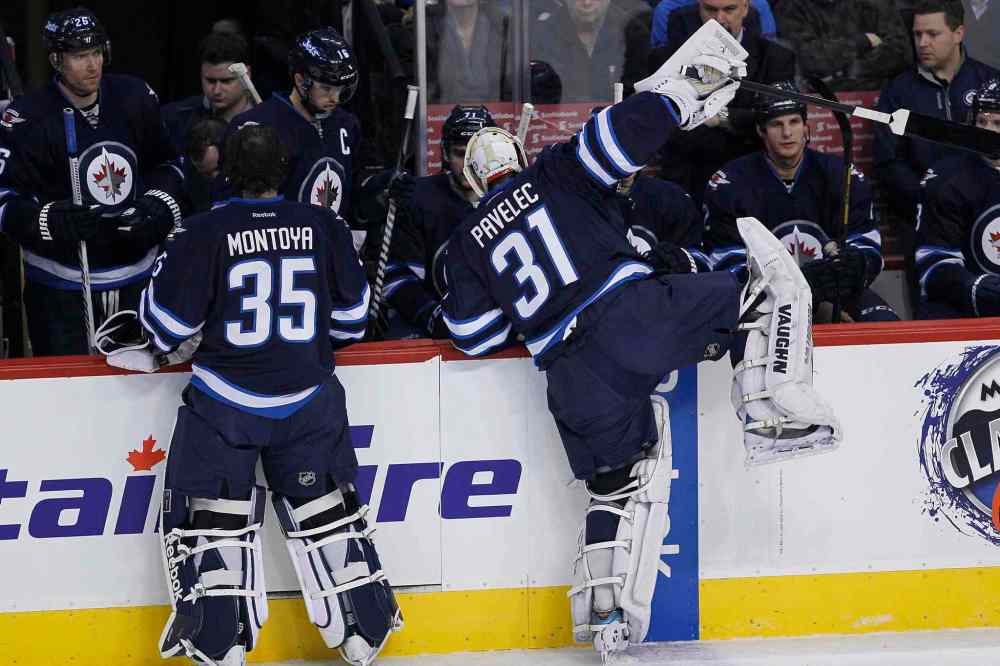 JOHN WOODS / THE CANADIAN PRESS
Winnipeg Jets goaltender Ondrej Pavelec (right) climbs over the boards in frustration after being pulled during the first period. Al Montoya (left) came in to replace Pavelec.