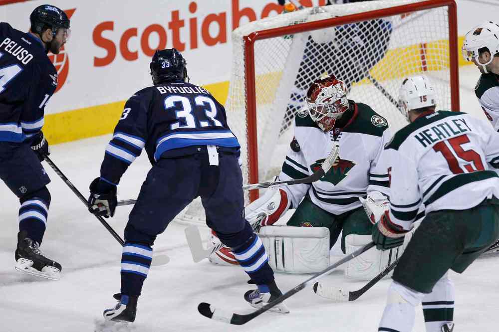 JOHN WOODS / THE CANADIAN PRESS
Winnipeg Jets defenceman Dustin Byfuglien (33) scores on Minnesota Wild goaltender Niklas Backstrom (32) as Anthony Peluso (left) of the Jets and Dany Heatley and Nate Prosser of the Wild look on during the first period.