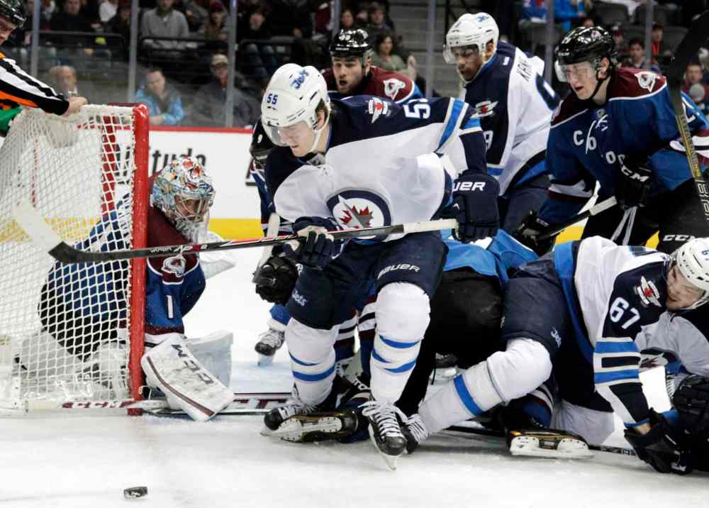 Joe Mahoney / The Associated Press
Winnipeg Jets center Mark Scheifele (front) chases the puck behind the net during the second period.