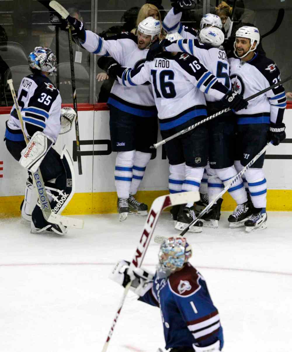 Joe Mahoney / The Associated Press
Winnipeg Jets goalie Al Montoya (left) skates toward his teammates to celebrate the team's overtime victory as Avalanche goalie Semyon Varlamov (bottom) skates to the bench.
