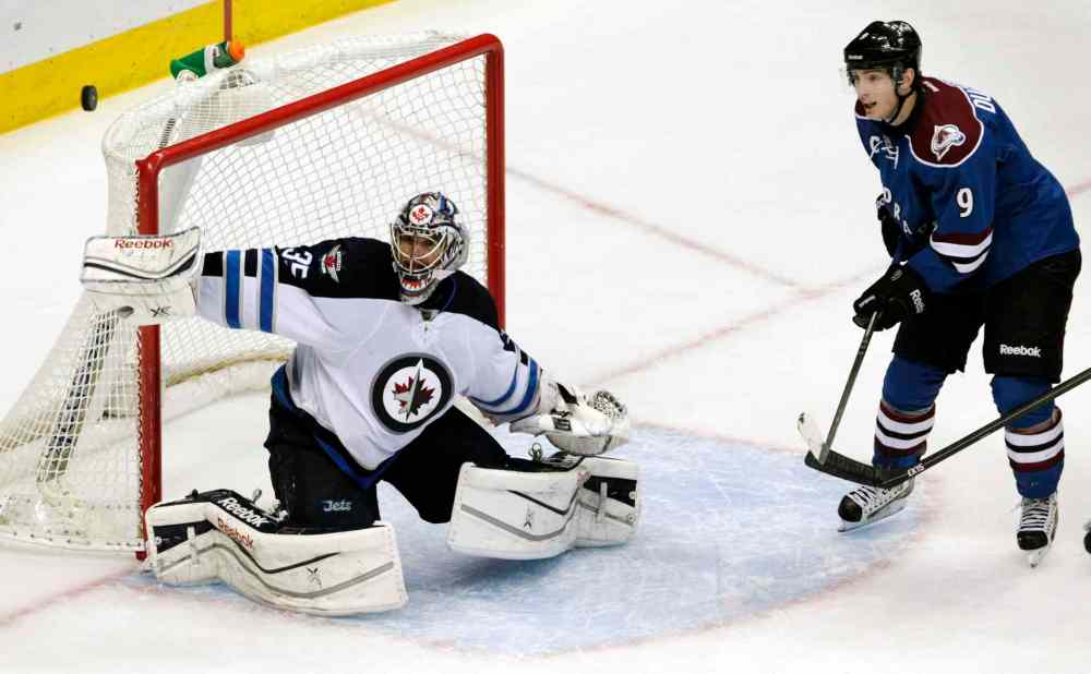 Joe Mahoney / The Associated Press
With his stick in his own net, Winnipeg Jets goalie Al Montoya (left) blocks a shot as Colorado Avalanche center Matt Duchene moves into the crease during overtime.