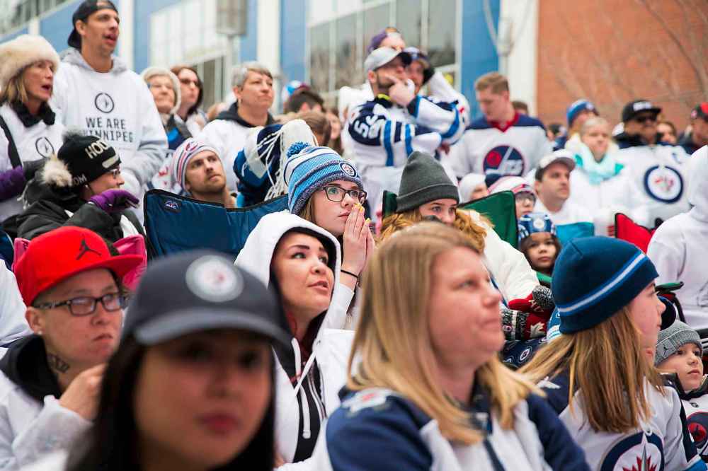 MIKAELA MACKENZIE / WINNIPEG FREE PRESS
Fans watch the first period at the Jets whiteout party on Donald St.