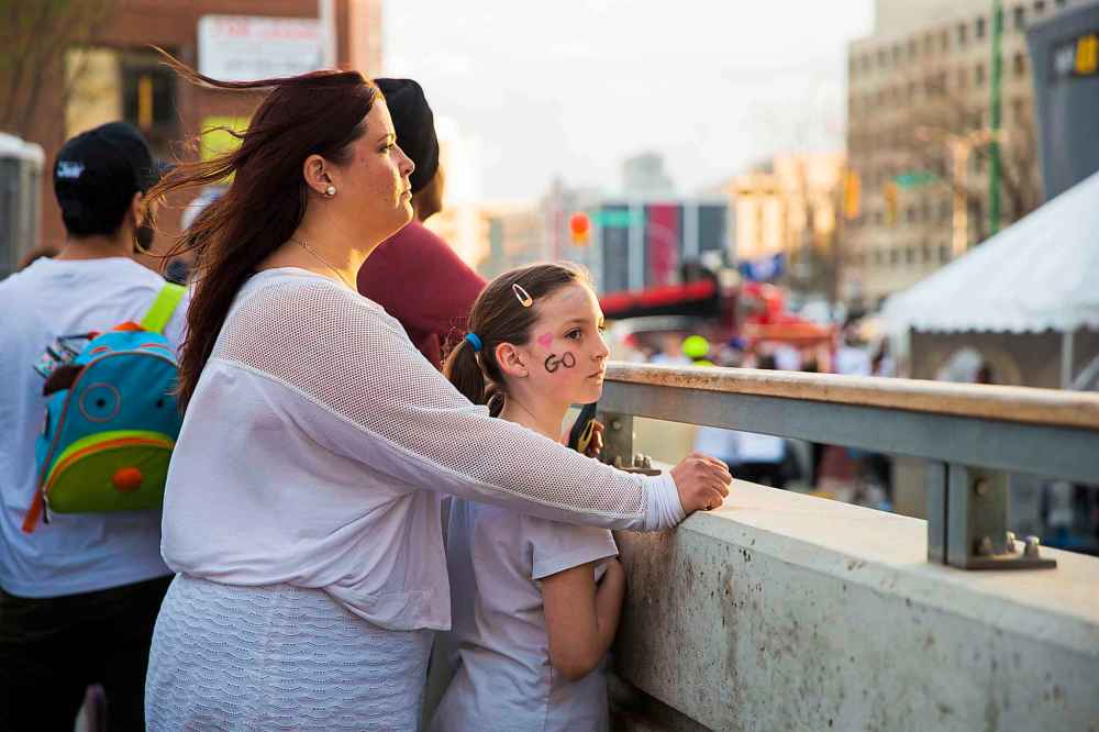 MIKAELA MACKENZIE / WINNIPEG FREE PRESS
Vanessa MacKeil and her daughter, Amelia (8), watch the whiteout street party before the game starts, Monday.