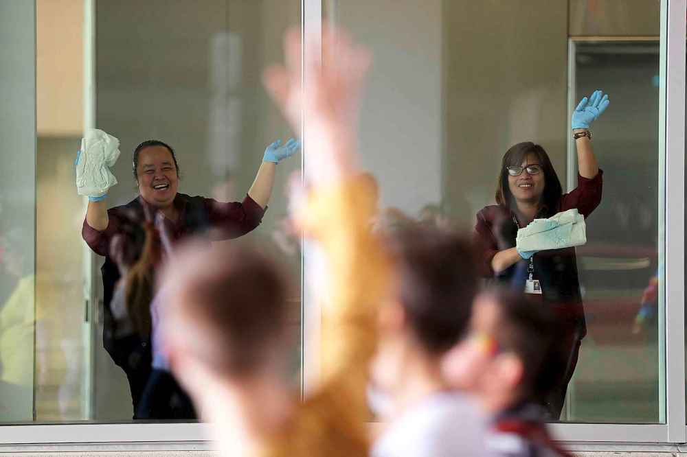 Window washers inside the convention centre watching the Pride Parade, Sunday, June 3, 2018.