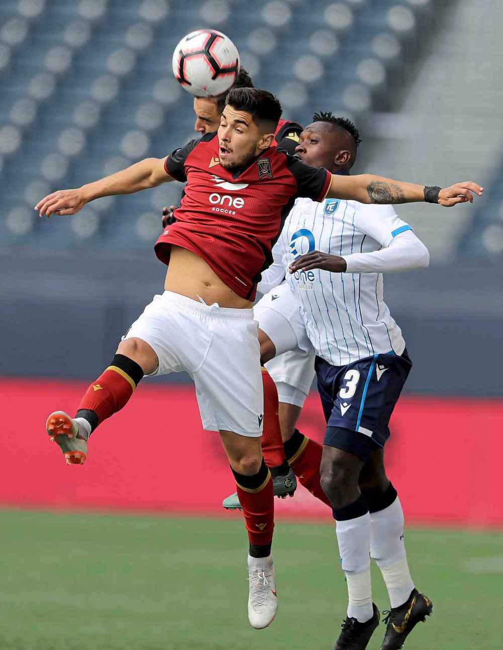 Member of Valour FC and FC Edmonton fight to take the ball.