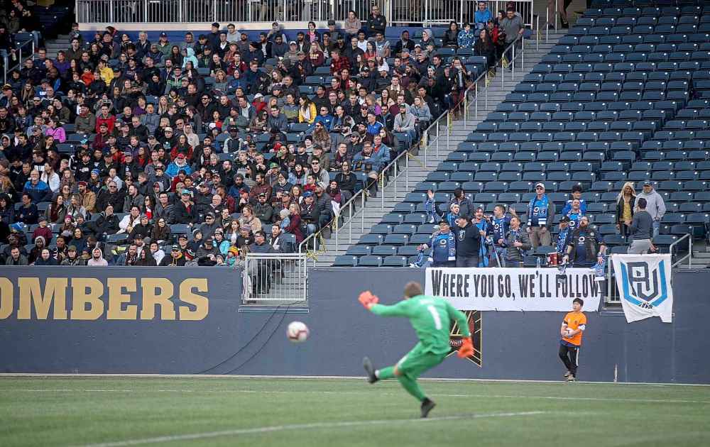 A small but passionate group of FC Edmonton fans cheer as their goalkeeper Connor James as he kicks the ball away against Valour FC.