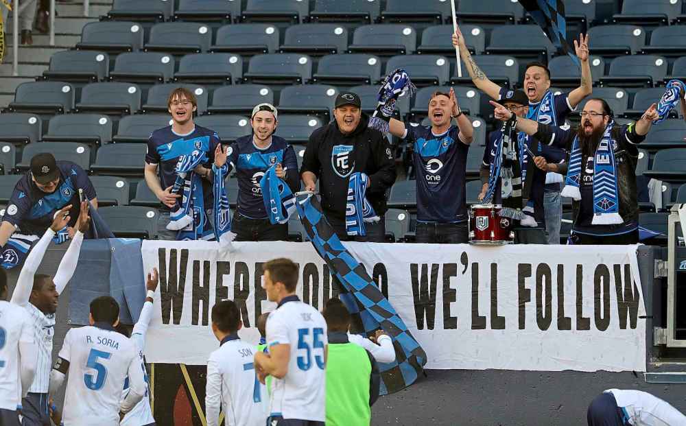 FC Edmonton fans celebrate with the team after they defeat Valour FC.