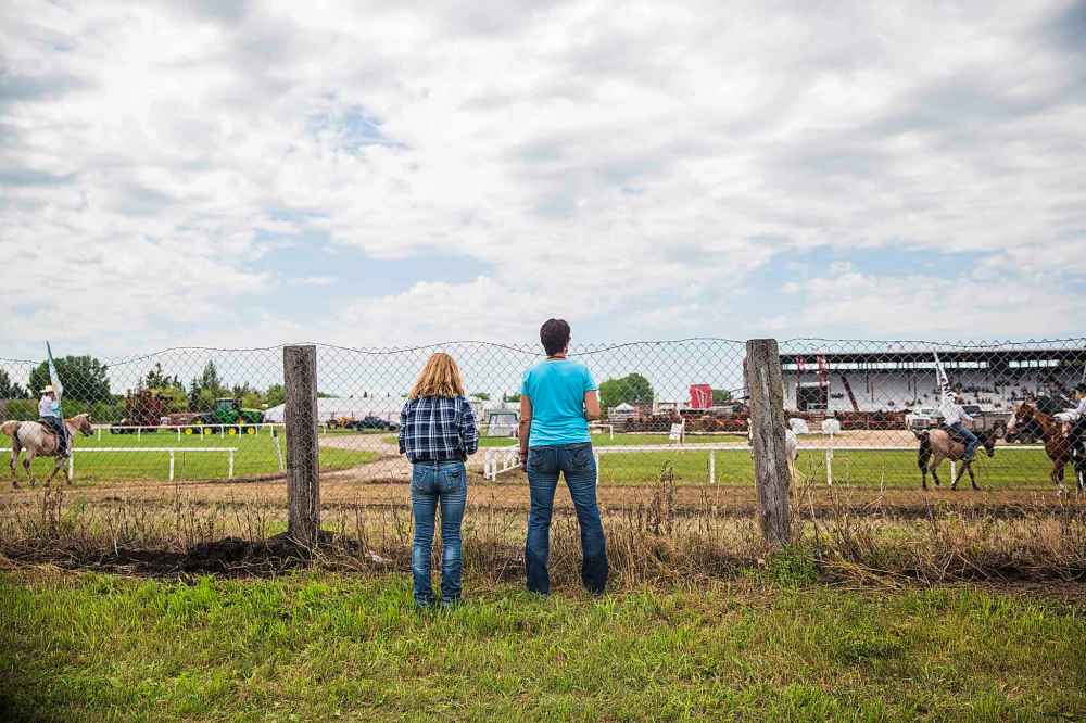 Rodeo director Cheryl Sarrasin and her 14-year-old niece, Haleyna Fehr, watch the rodeo from the camp.