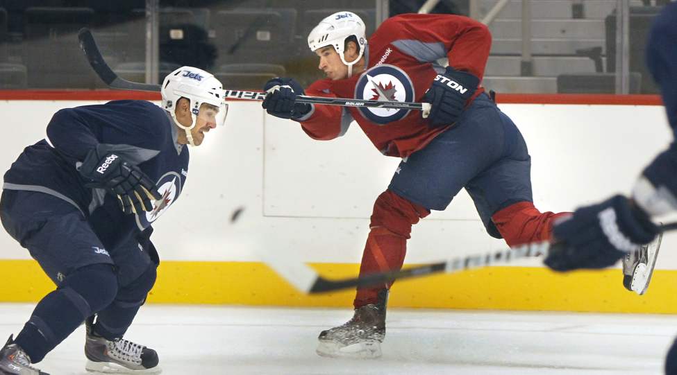 WAYNE GLOWACKI/WINNIPEG FREE PRESS
Troy Bodie, right, fires a puck past Travis Ramsey in the MTS Centre Monday.