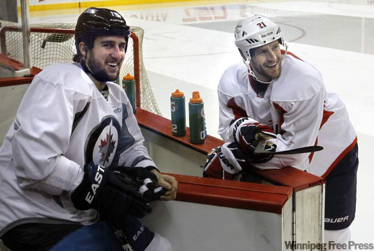 WAYNE GLOWACKI / WINNIPEG FREE PRESS
At left, Winnipeg Jets left-winger Tanner Glass chats with Washington Capitals centre Brooks Laich as the ice is cleaned between practices at the MTS Centre Thursday.