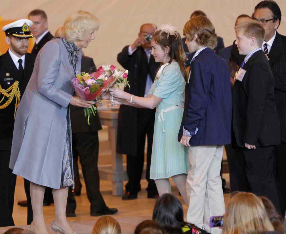 Wayne Glowacki / Winnipeg Free Press
Camilla, Duchess of Cornwall receives flowers from Avery Good, Ethan Enns and Ryan Petricig, three grade six scientists from Brant Argyle School in Argyle, MB. at the ceremony in the Stevenson Hangar Wednesday morning. Their science experiment was sent to the international Space Station to study how to protect astronauts from cancer caused by radiation.