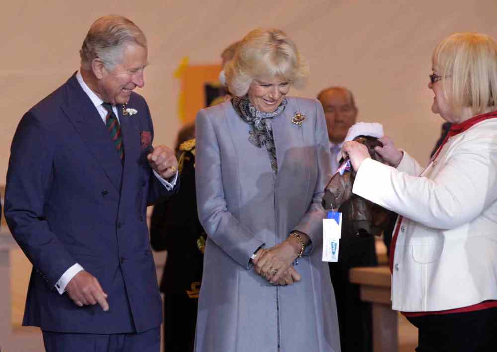 Wayne Glowacki / Winnipeg Free Press
At right, Barb Bowen presents Prince Charles and Camilla, Duchess of Cornwall a flight jacket for Prince George at the ceremony in the Stevenson Hangar Wednesday morning.