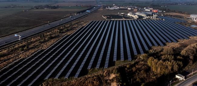 FILE -- A solar farm, front, and a biogas plant, rear, are seen in Oberkraemer, Germany, Thursday, Oct. 28, 2021. The German government presented a major package of reforms Wednesday to boost the construction of renewable power as part of its efforts to meet its climate goals and become independent of energy imports from hostile nations such as Russia. (AP Photo/Michael Sohn, file)