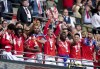 Nottingham Forest's Joe Worrall, centre, lifts the trophy in the stands as he celebrates with teammates, winning promotion to the English Premier League, following the Championship play-off final against Huddersfield, at Wembley Stadium, London, Sunday May 29, 2022. (Mike Egerton/PA via AP)
