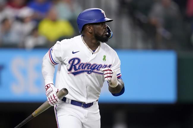 Texas Rangers' Adolis Garcia hangs out to the bat as he heads to first after hitting a two-run home run against the Tampa Bay Rays in the fourth inning of a baseball game, Tuesday, May 31, 2022, in Arlington, Texas. The shot also scored Mitch Garver. (AP Photo/Tony Gutierrez)