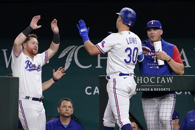 Texas Rangers' Kole Calhoun, left, and bench coach/offensive coordinator Donnie Ecker, right, celebrate with Nathaniel Lowe (30) after Lowe hit a solo home run against the Tampa Bay Rays during the fourth inning of a baseball game Wednesday, June 1, 2022, in Arlington, Texas. (AP Photo/Tony Gutierrez)