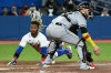 Toronto Blue Jays left fielder Raimel Tapia slides safely into home ahead of a tag by Chicago White Sox catcher Yasmani Grandal, right, on a double by Jays second baseman Santiago Espinal during fifth inning American League baseball action in Toronto on Thursday, June 2, 2022. THE CANADIAN PRESS/Jon Blacker