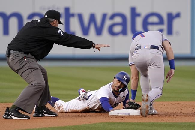 Los Angeles Dodgers' Mookie Betts, center, looks to second base umpire Manny Gonzalez, left, after stealing second as New York Mets second baseman Jeff McNeil puts a late tag on him during the first inning of a baseball game Thursday, June 2, 2022, in Los Angeles. (AP Photo/Mark J. Terrill)