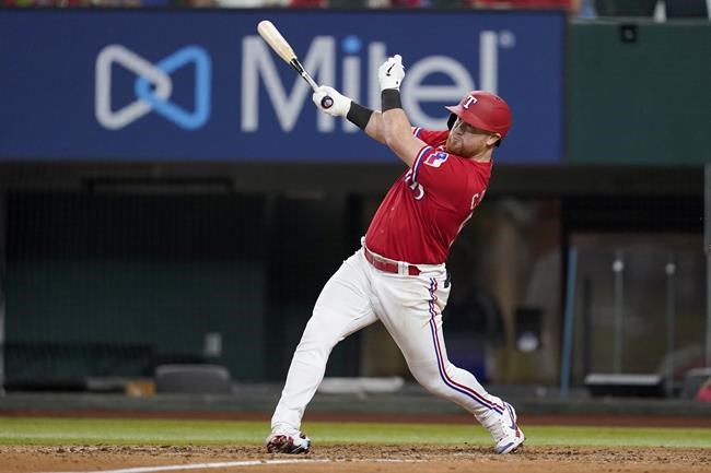 Texas Rangers' Kole Calhoun follows through on a run-scoring double in the sixth inning of a baseball game against the Seattle Mariners, Friday, June 3, 2022, in Arlington, Texas. Corey Seager scored on the play. (AP Photo/Tony Gutierrez)