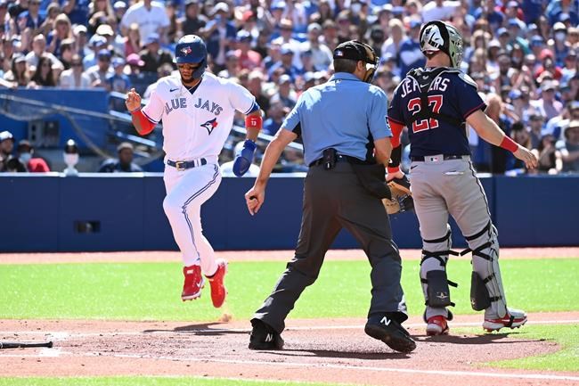 Toronto Blue Jays left fielder Lourdes Gurriel Jr (13) scores on a check swing single by teammate centre fielder George Springer as Minnesota Twins catcher Ryan Jeffers (27) looks on during second inning American League baseball action in Toronto on Saturday, June 4, 2022. THE CANADIAN PRESS/Jon Blacker