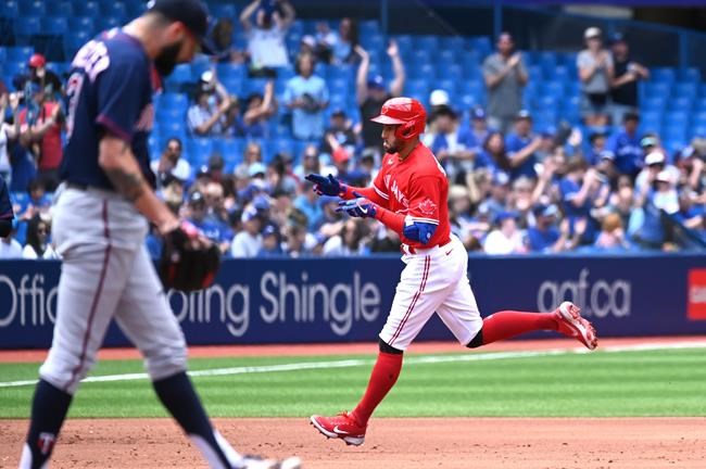 Toronto Blue Jays’ centre-ielder George Springer (4), right, rounds the bases after hitting a solo home run off Minnesota Twins’ starting pitcher Devin Smeltzer (31), left, in the first inning of American League baseball action in Toronto on Sunday, June 5, 2022. THE CANADIAN PRESS/Jon Blacker