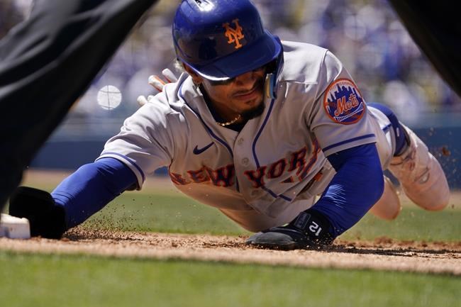 New York Mets' Francisco Lindor dives back to first during the sixth inning of a baseball game against the Los Angeles Dodgers Sunday, June 5, 2022, in Los Angeles. (AP Photo/Mark J. Terrill)