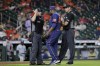 Houston Astros relief pitcher Hector Neris, middle, protests his ejection with umpires Chris Guccione, left, and Jordan Baker, right, after Neris threw at the head of Seattle Mariners batter Eugenio Suarez during the ninth inning of a baseball game Monday, June 6, 2022, in Houston. Neris was ejected from the game for the pitch, which happened on the next batter after Neris hit Seattle Mariners' Ty France, causing both dugouts to empty with ejections on both teams. (AP Photo/Michael Wyke)
