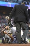 Umpire Alan Porter, top, watches as Colorado Rockies catcher Elias Diaz holds the ball after tagging out San Francisco Giants' Luis Gonzalez at home during the fifth inning of a baseball game in San Francisco, Wednesday, June 8, 2022. (AP Photo/Jeff Chiu)