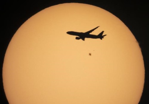A cargo Boeing 777 of China Southern Airlines flying from Amsterdam to Shanghai is silhouetted against the sun as it flies over the village of Podolye, 70 kilometers (43 miles) east of St. Petersburg, Russia, on Oct. 11, 2021. An industry group representing most major airlines criticized the European Union's Parliament on Thursday, June 9, 2022 for seeking to expand its emissions trading system to all departing flights. (AP Photo/Dmitri Lovetsky, File)
