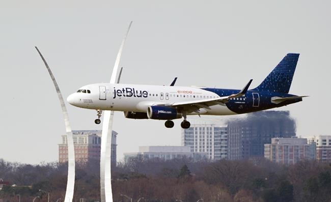A JetBlue passenger flight passes the Air Force Memorial as it prepares to land at Reagan Washington National Airport in Arlington, Va., across the Potomac River from Washington, Wed., Jan. 19, 2022. U.S. airline JetBlue launched its service to Canada with the first flight arriving in this evening in Vancouver from New York's JFK International Airport. THE CANADIAN PRESS/AP-J. Scott Applewhite