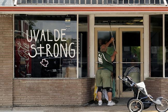 A window washer work around the town square, Thursday, June 9, 2022, in Uvalde, Texas. Uvalde is home to the Texas elementary school where a gunman killed 19 children and two teachers has long been a part of the fabric of the small city of Uvalde, a school attended by generations of families, and where the spark came that led to Hispanic parents and students to band together to fight discrimination over a half-century ago. (AP Photo/Eric Gay)
