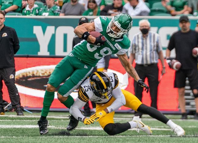 Hamilton Tiger-Cats defensive back Jumal Rolle (25) tackles Saskatchewan Roughriders receiver Kian Schaffer-Baker (89) during first half CFL football action in Regina on Saturday, June 11, 2022. THE CANADIAN PRESS/Heywood Yu