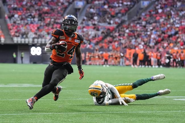 B.C. Lions' James Butler, left, gets away from a tackle by Edmonton Elks' Trey Hoskins and runs the ball in for his first touchdown during the first half of CFL football game in Vancouver, on Saturday, June 11, 2022. THE CANADIAN PRESS/Darryl Dyck