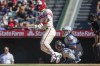 Los Angeles Angels designated hitter Mike Trout, left, hits a run-scoring single to score Brandon Marsh with New York Mets catcher Tomas Nido, second from right, looking on during the first inning of a baseball game in Anaheim, Calif., Sunday, June 12, 2022. (AP Photo/Alex Gallardo)