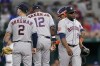 Houston Astros' Alex Bregman (2), manager Dusty Baker Jr. (12) and catcher Martin Maldonado, right, rear, stand on the mound as relief pitcher Hector Neris (50) walks to the dugout after turning the ball over in the eighth inning of a baseball game against the Texas Rangers, Monday, June 13, 2022, in Arlington, Texas. (AP Photo/Tony Gutierrez)
