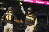 San Diego Padres' Ha-Seong Kim, right, stands near first base coach David Macias and acknowledges his teammates' cheers after hitting an RBI single during the sixth inning of the team's baseball game against the Chicago Cubs on Tuesday, June 14, 2022, in Chicago. (AP Photo/Charles Rex Arbogast)