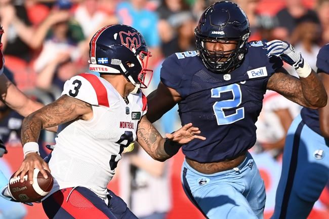 Montreal Alouettes quarterback Vernon Adams Jr (3) scrambles before getting sacked by Toronto Argonauts' Shawn Oakman (2) during first half CFL football action in Toronto Thursday, June 16, 2022. THE CANADIAN PRESS/Jon Blacker