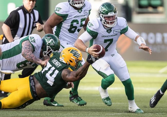 Saskatchewan Roughriders quarterback Cody Fajardo (7) gets by Edmonton Elks' Makana Henry (74) during first half CFL action in Edmonton, Alta., on Saturday June 18, 2022. THE CANADIAN PRESS/Jason Franson.