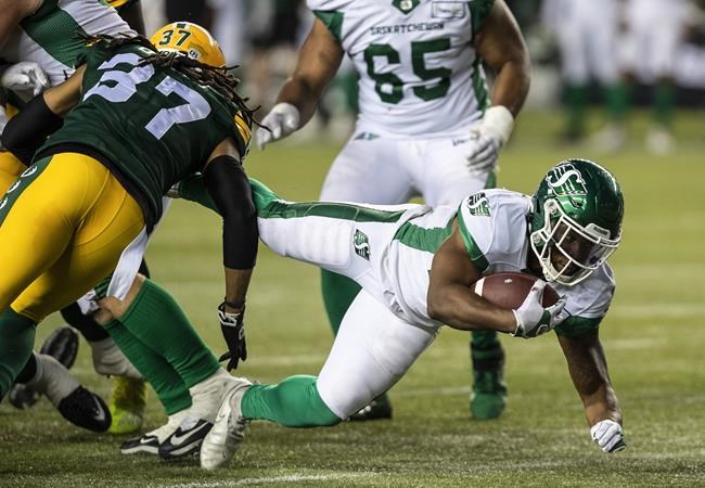 Saskatchewan Roughriders' Jamal Morrow (25) is tackled by Edmonton Elks' Treston Decoud (37) during second half CFL action in Edmonton, Alta., on Saturday June 18, 2022. Calgary defensive back Titus Wall, Stampeders kicker Rene Paredes and Saskatchewan running back Morrow are the CFL's top players for Week 2 of the season.THE CANADIAN PRESS/Jason Franson.