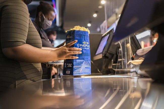 Customers buy popcorn at a Cineplex theatre in downtown Toronto on Wednesday, Aug. 26, 2020. ;Cineplex Inc. says it's started charging a $1.50 per ticket booking fee for purchases made through its mobile app and website. THE CANADIAN PRESS/Christopher Katsarov