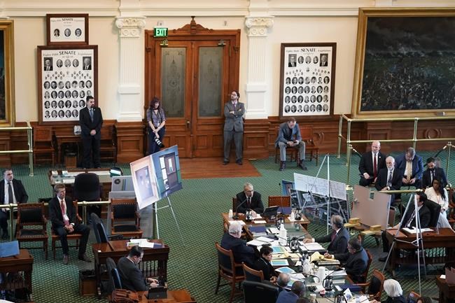 Using photos of doors from Robb Elementary School in Uvalde, Texas, Texas Department of Public Safety Director Steve McCraw, seated center, testifies at a Texas Senate hearing at the state capitol, Tuesday, June 21, 2022, in Austin, Texas. Two teachers and 19 students were killed in last month's mass shooting in Uvalde. (AP Photo/Eric Gay)