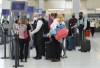People wait in line to check in at Pearson International Airport in Toronto on Thursday, May 12, 2022. Canada's transport regulator is beefing up passenger protection rules, placing more stringent rules around reimbursement by airlines. THE CANADIAN PRESS/Nathan Denette