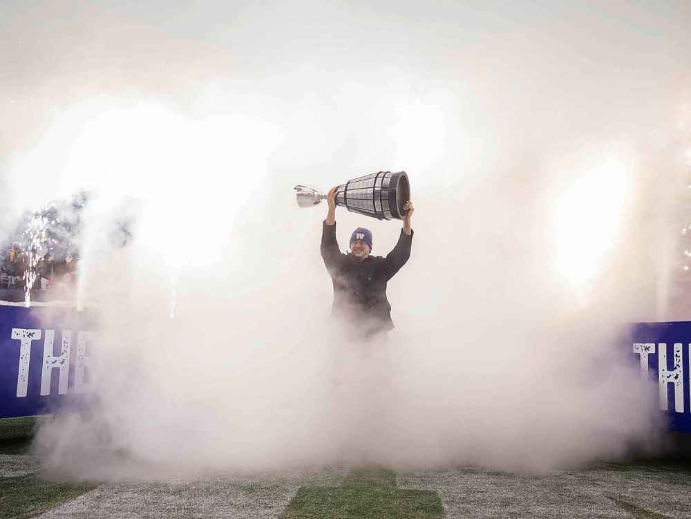 Bombers player Zach Collaros emerges from the smoke holding the Grey Cup. (Jessica Lee / Winnipeg Free Press)