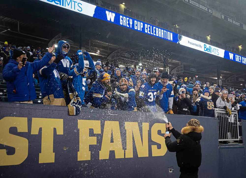 Bombers player Kenny Lawler sprays fans with champagne. (Jessica Lee / Winnipeg Free Press)