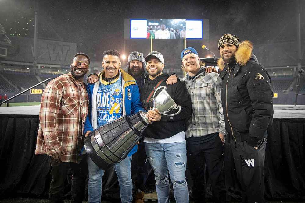 Bombers players (from left to right) Johnny Augustine, Andrew Harris, Pete Constanza (RB coach), Brady Oliveira, Mike Miller and Kenny Lawler celebrate the recent Grey Cup victory. (Jessica Lee / Winnipeg Free Press)