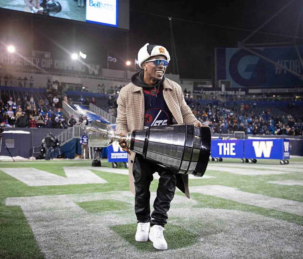 Bombers player Winston Rose holds the Grey Cup. (Jessica Lee / Winnipeg Free Press)